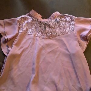 Pink blouse. One button on the back. Lacey front. Lightly ruffles sleeves.